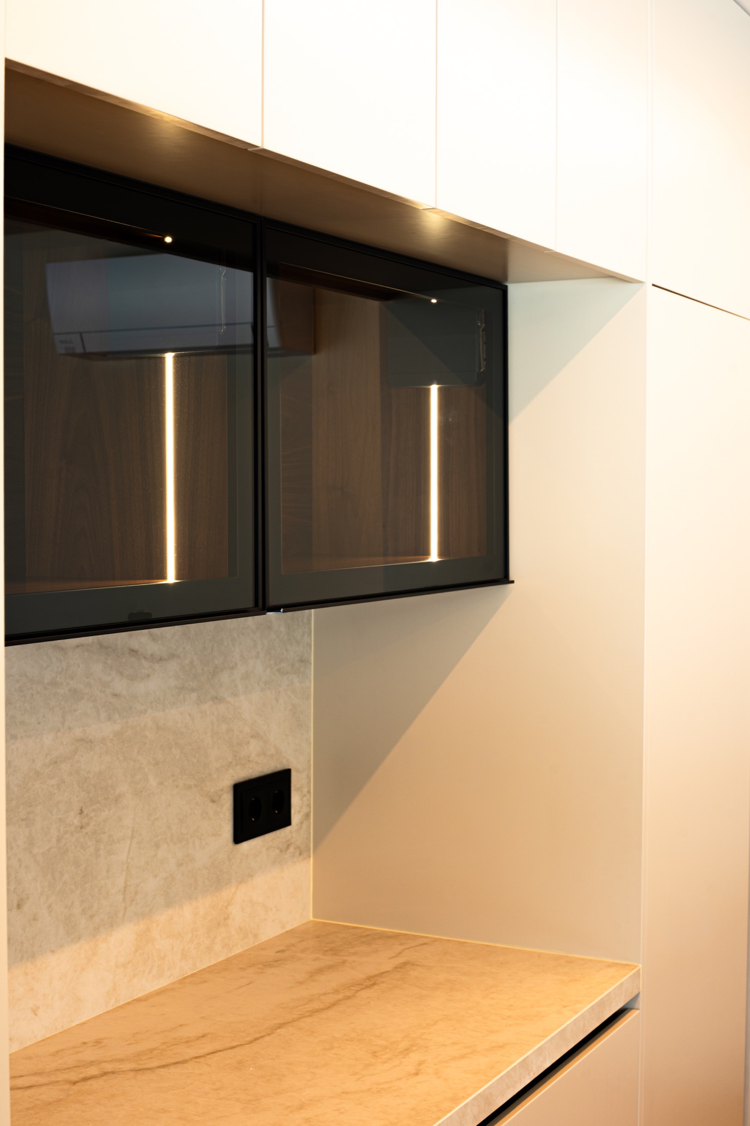 Detalhe de cozinha clara com vitrines iluminadas